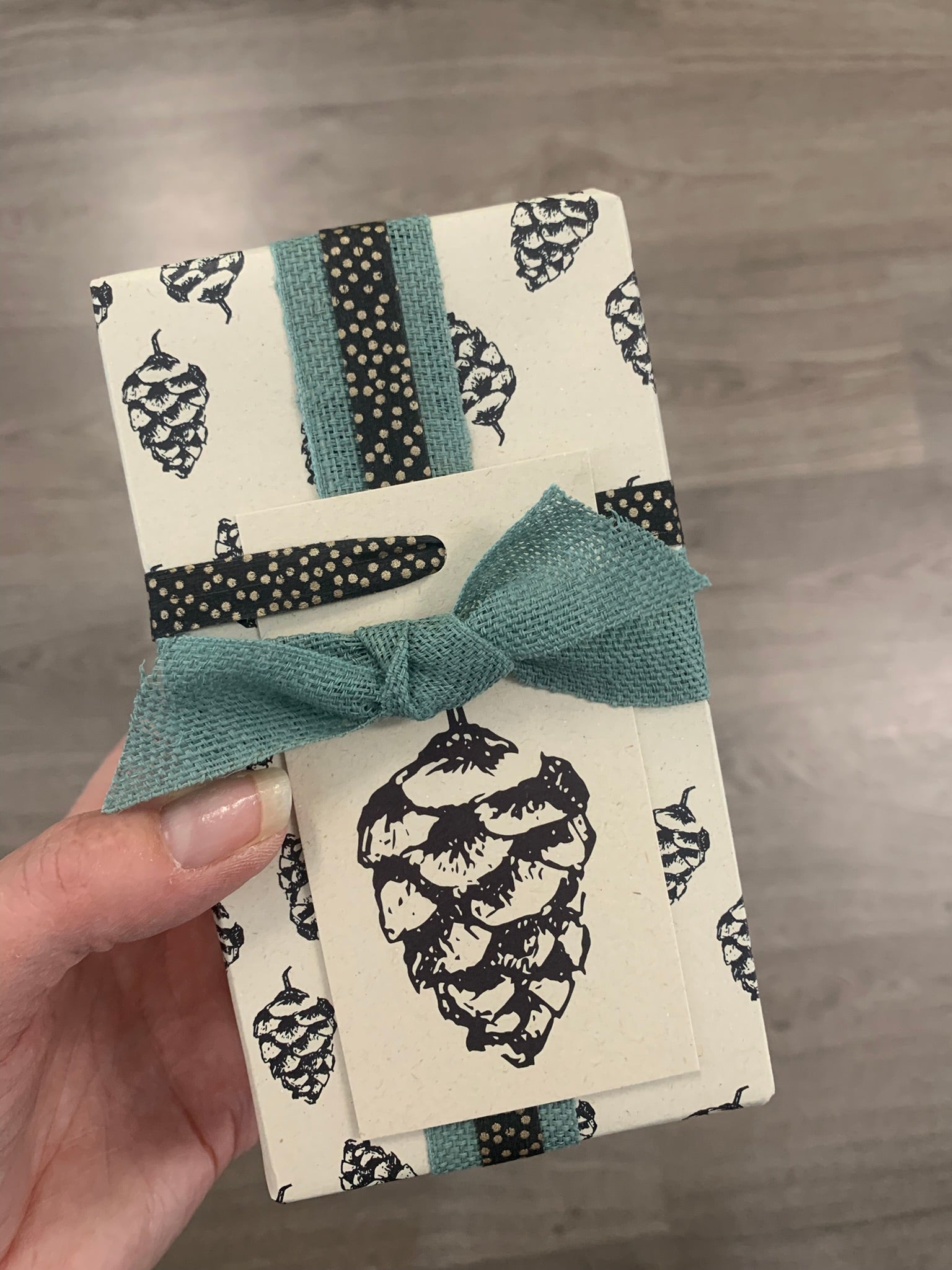 Cadeautje, ingepakt in duurzaam inpakpapier gemaakt van landbouwrestafval | Dennenappel